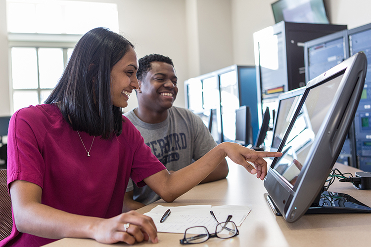 female and male UNC Charlotte student looking at computer